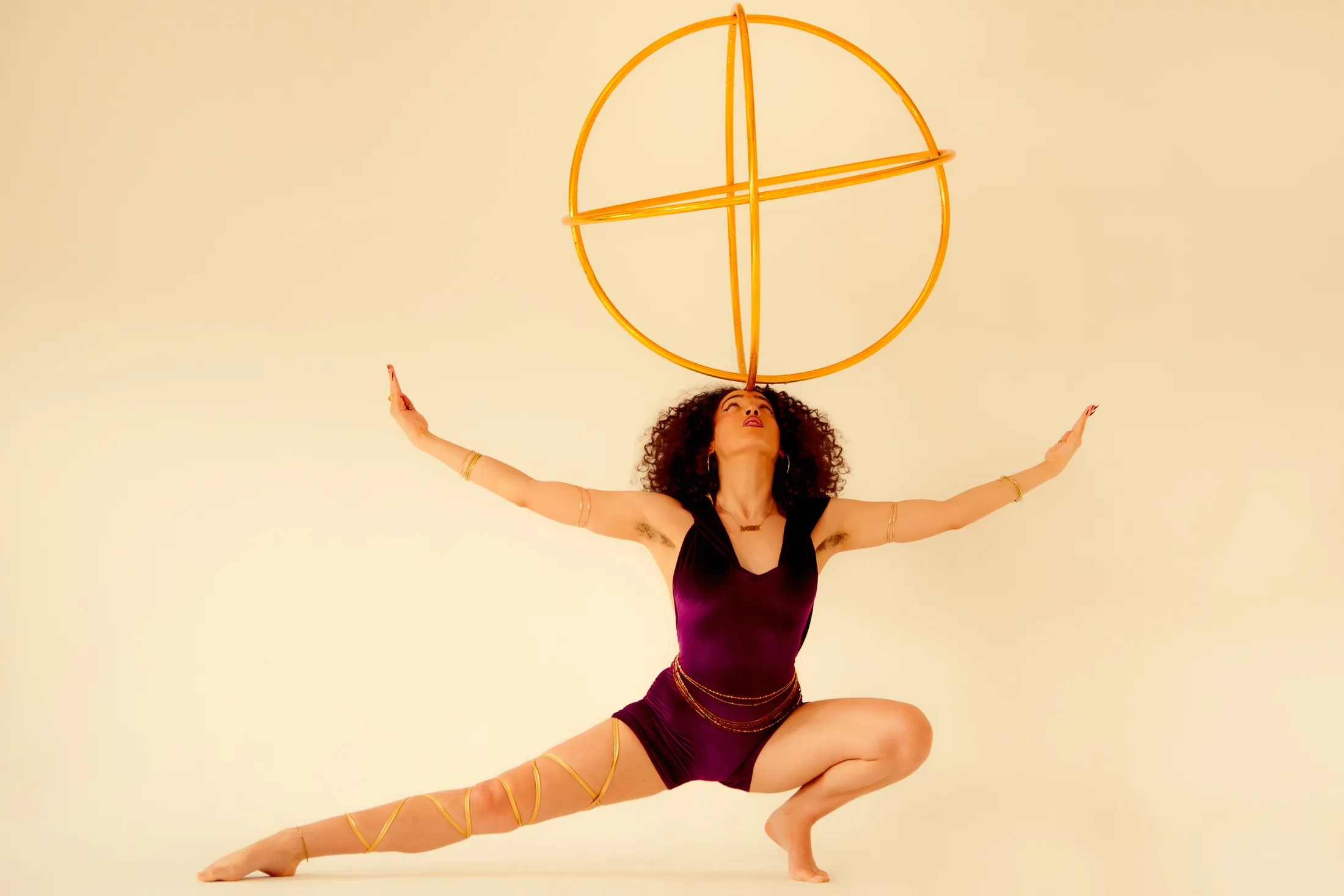 JayJayDivine balancing a hoop in a wide performance pose